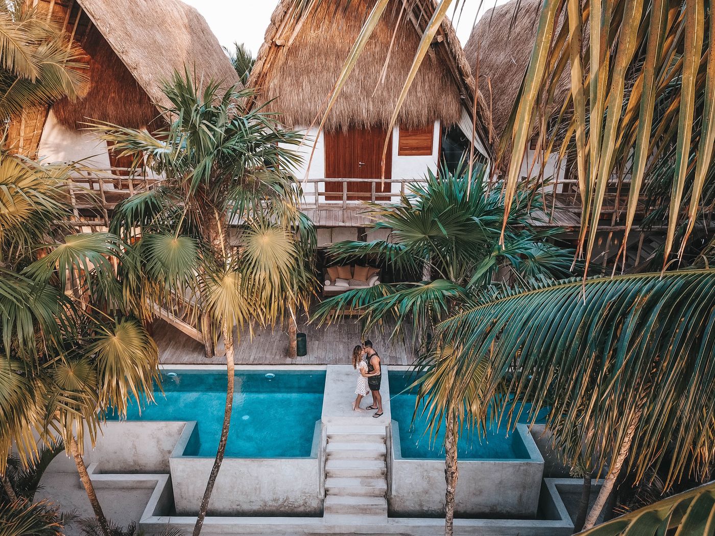 Lune de miel : Comment bien préparer son voyage de noces ? - Couple qui s'embrasse près d'une piscine dans un hotel de luxe en voyage