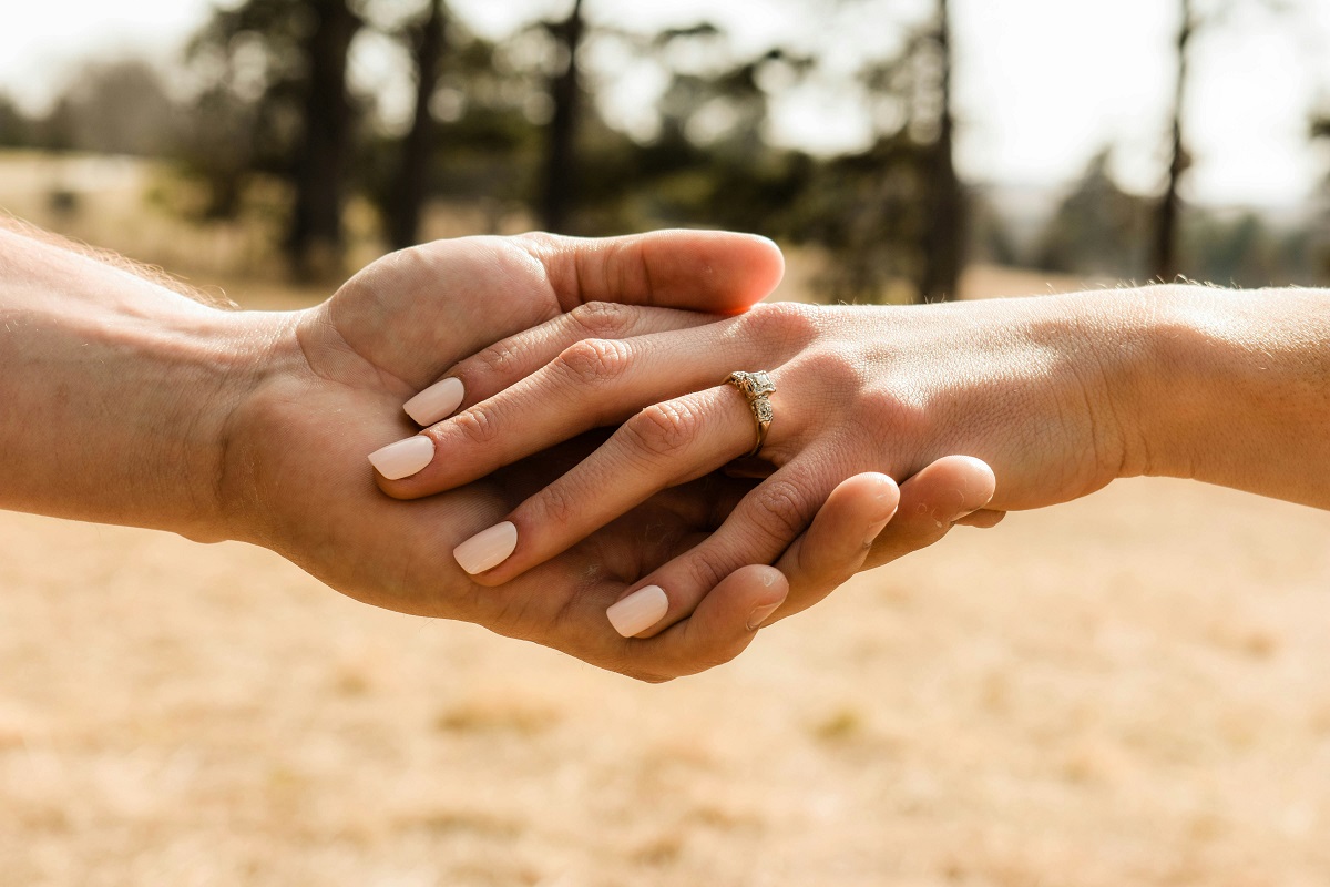 couple qui se tient la main. la mariée à une manucure de mariage nude